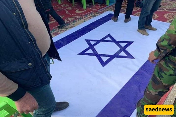 بصوره تثیر إعجاب الملایین: عندما سحق الإمام الخامنئی الکیان الصهیونی بخطوه واحده — صوره للعلم الإسرائیلی تحت قدم قائد الثوره تتصدر وسائل التواصل